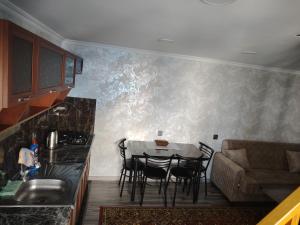 eine Küche und ein Esszimmer mit Tisch und Stühlen in der Unterkunft AGA Frame in Qusar