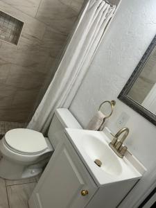 Sunny guest suite near the beach في برادنتون: حمام أبيض مع مرحاض ومغسلة