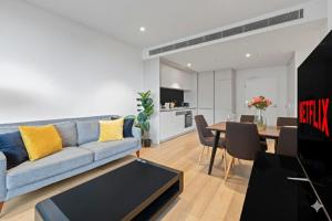 シドニーにあるCentral 2 Bedroom Condo Haymarketの青いソファとテーブルのあるリビングルーム