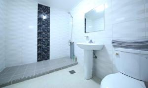 a white bathroom with a toilet and a sink at Yangji Resortel in Hwaseong +39 photos