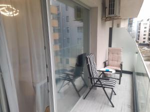 ein Balkon mit zwei Stühlen und einem Tisch in der Unterkunft Studio Valeria - Promenada Signature , Mamaia Nord in Năvodari + 6 Fotos