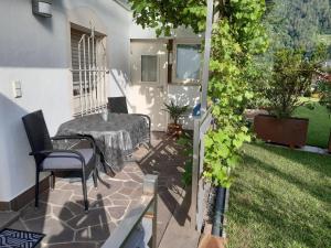 a patio with a table and chairs in a yard at Ferienwohnungen Pircher in Rablà +17 photos