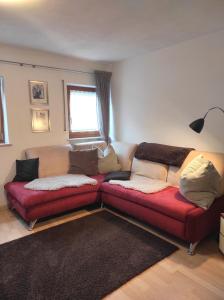 a living room with a red couch and a window at Ferienwohnungen Pircher in Rablà