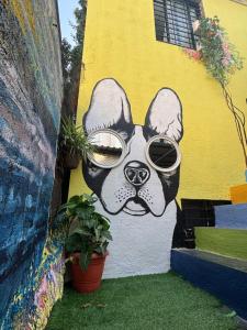 a wall with a painting of a dog wearing sunglasses at KKOZY NOOk in Aurangabad +4 photos