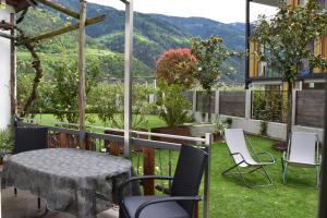 a patio with a table and chairs on the grass at Ferienwohnungen Pircher in Rablà