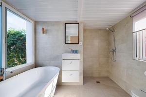 a bathroom with a tub and a sink and a mirror at Casa Boletes, with splendid views! in Cartagena +14 photos
