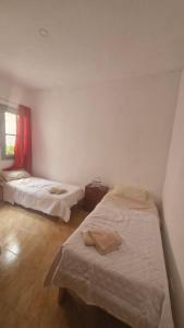 a room with two beds in it with a window at Dpto 6 in La Cieneguita