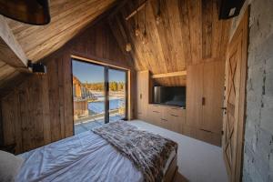 una camera da letto con un letto e una grande finestra di WHITE BROOK Luxury Chalets a Witów