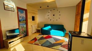 a living room with a blue couch and a television at Casa Producena in Valdidentro