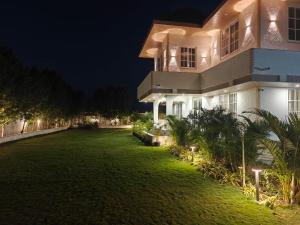 a large yard in front of a house at night at Palms Villa in Dharmpura
