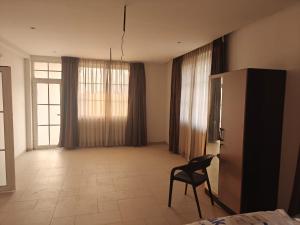 a room with a chair and a large window at Palms Villa in Dharmpura