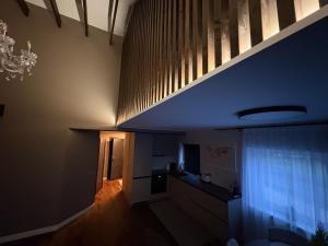 a hallway with a staircase with a window and a chandelier at Telšiai Modern Central Apartments in Telšiai