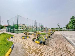 uma fileira de vasos de plantas em uma estrada de tijolos em Coastal Green resort em Mahabalipuram