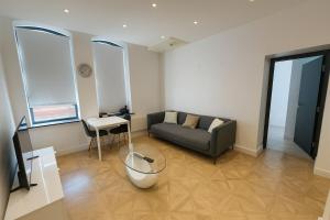 uma sala de estar com um sofá e uma mesa em Leeds Central Cosy 1BD Flat 10 mins to Station! em Leeds