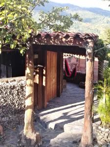 un riparo di legno con un albero di fronte a un edificio di Bella Vista Suites Mérida a Tabay