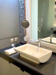 ein Badezimmer mit einem großen weißen Waschbecken auf der Theke in der Unterkunft Premium Seafront Suite in Thessaloniki