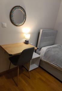 a desk with a lamp and a bed with a mirror at Η πέρλα της λίμνης/ The lake's pearl in Ioannina