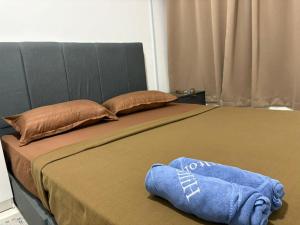 a large bed with a blue towel on it at The Duta Loft in Bandar Puncak Alam