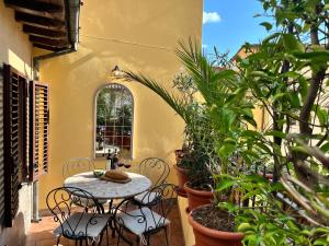 a patio with a table and chairs and plants at Gorgeous sunlit townhouse with terrace in medieval Pescia, Tuscany in Pescia