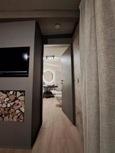 a hallway with a room with a fireplace and a bathroom at VHĀUS Apartment and Spa in Predazzo