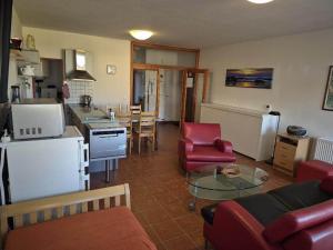 a kitchen and living room with a couch and a table at APT C-3 v areálu DOKY LIPNO - bezbariérový in Lipno nad Vltavou