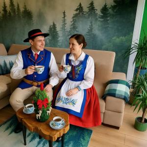 a man and woman in traditional clothing drinking coffee at Leśna Przystań Rumia - obok Gdyni i Aquaparku Reda in Rumia