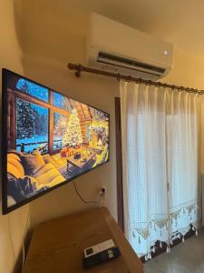 einen Flachbild-TV an einer Wand im Wohnzimmer in der Unterkunft Lykno Pozar in Kato Loutraki