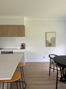 Una cocina y un comedor con mesa y sillas. en Family Holiday Home Ulladulla, en Ulladulla