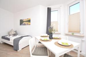 a white room with a table and a bed at NÜ06-BP - Apartment for companies in Zirndorf +14 photos