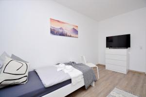 a white bedroom with a bed and a tv at NÜ06-BP - Apartment for companies in Zirndorf
