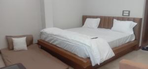 a bedroom with a large bed with white sheets and pillows at Moon palace in Maheshwar +2 photos