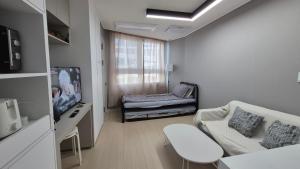 Una sala de estar con un sofá y un televisor. en West Ocean View of Nick's home, en Toran-mal