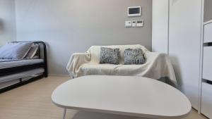 - Silla blanca con 2 almohadas en una habitación en West Ocean View of Nick's home, en Toran-mal