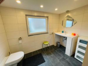 a bathroom with a toilet and a sink and a window at Ferienwohnung Monteurwohnung Sulingen in Sulingen