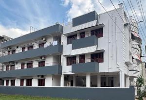 ein weißes Gebäude mit Balkonen an der Seite in der Unterkunft Sudha Grand Guestinn in Nellore