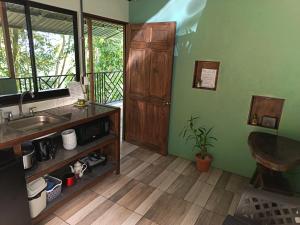a kitchen with a sink and a wooden door at Breezes Ecolodge in San Ramón