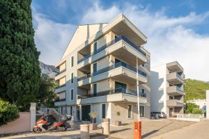 a building with a scooter parked in front of it at Villa Jakov Apartments II in Promajna