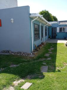 a blue house with a grass yard next to it at Casa para disfrutar en Necochea 5 personas in Necochea