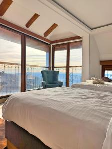 Un dormitorio con una cama y vista al mar. en Hotel Mujen Lux Tutic - Free Spa & Wellness, en Kopaonik