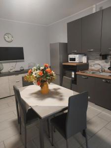 Una cocina con una mesa con un jarrón de flores encima. en Girasole, en Alessandria