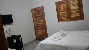 una camera da letto con un letto con asciugamani bianchi sopra di Pousada Do Gael a Estivado