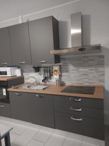 a kitchen with gray cabinets and a sink and a stove at Girasole in Alessandria