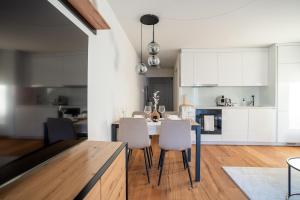 a kitchen with white cabinets and a table and chairs at Urban Comfort, Zurich Airport - By River Glatt in Glattbrugg
