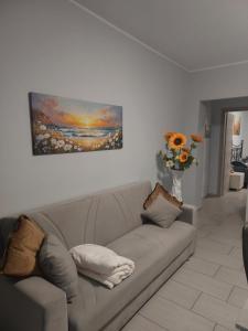 una sala de estar con sofá y un jarrón de flores en Girasole, en Alessandria