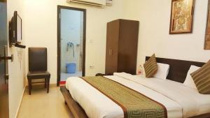 a bedroom with a large bed and a chair at HOTEL TWB Palace in Gwalior