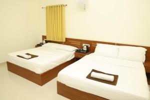 The Dew Nest في أوتي: سريرين في غرفة فندق مع مناشف عليهما