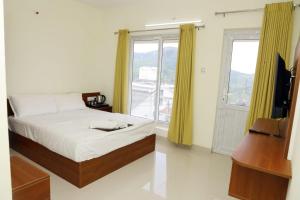 The Dew Nest في أوتي: غرفة نوم بها سرير وتلفزيون ونافذة