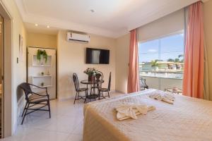 Villa Araçà - Boutique Hotel في لورو دي فريتاس: غرفة نوم بها سرير وطاولة وكراسي