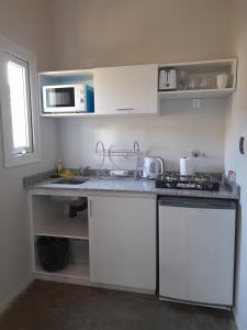 een keuken met witte kasten en een aanrechtblad bij Casa de Moras in Tandil