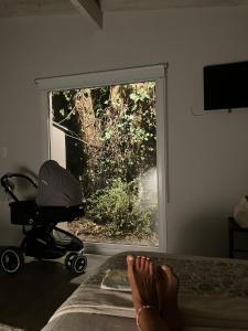 een persoon met zijn voeten op een bed met een kinderwagen bij Casa de Moras in Tandil